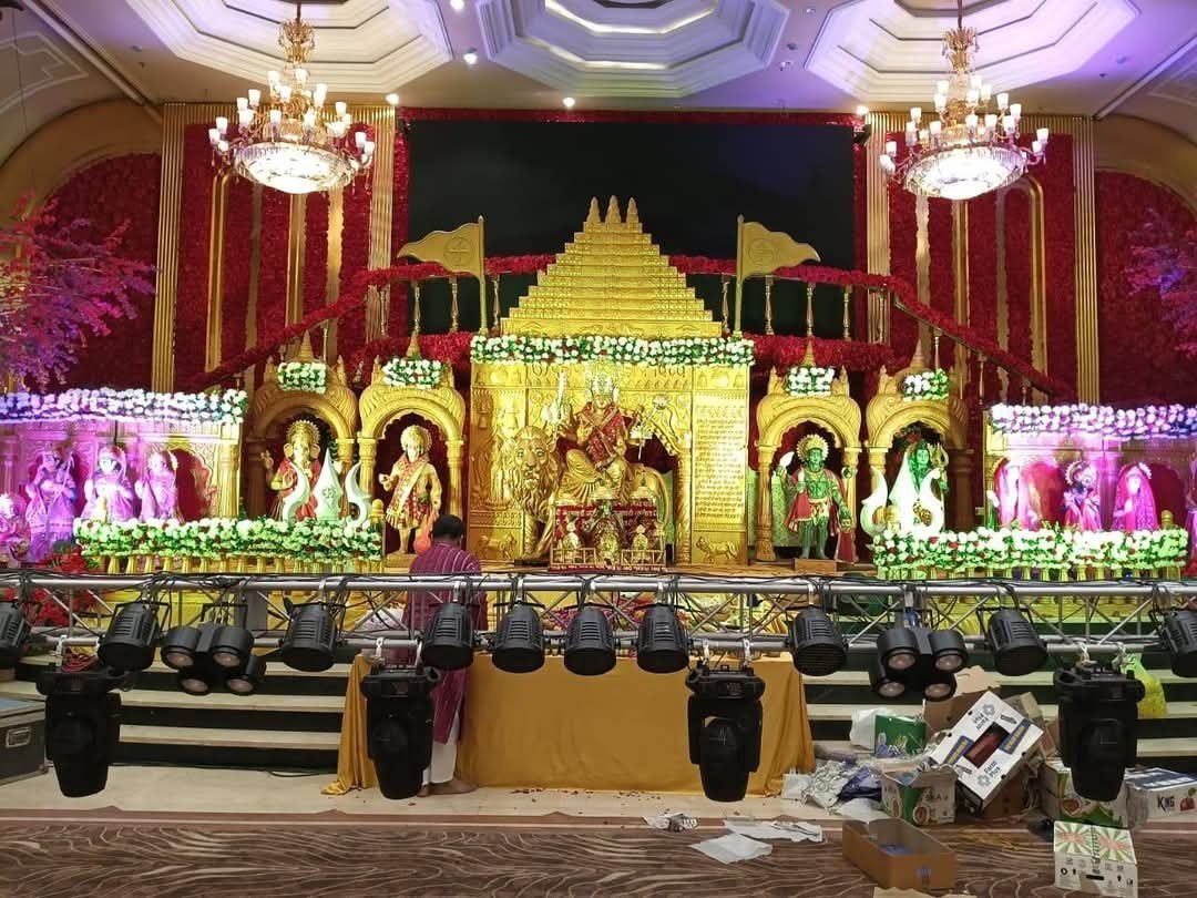 Elaborate golden darbar stage with deity idols, floral garlands and stage lighting prepared for a jagran