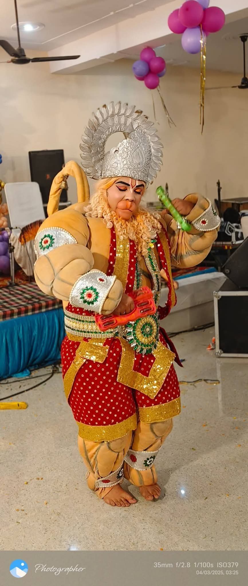 Artist performing as Hanuman in full costume and crown at a devotional celebration